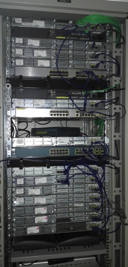 The top half of the 42U lab rack, full of Cisco routers and switches with labelled patch cables